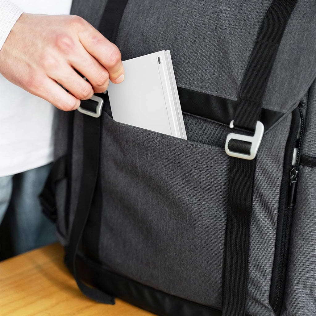 White B023 foldable wireless keyboard being placed into a backpack pocket, emphasizing its portability and travel readiness.