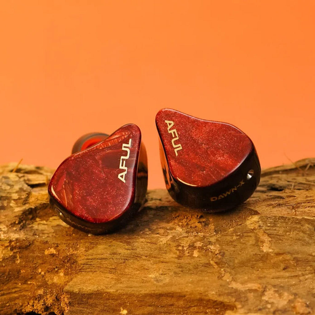 AFUL DAWN-X IEMs displayed on wood with red marbled finish and gold branding, combining luxury aesthetics with high-end audio technology.