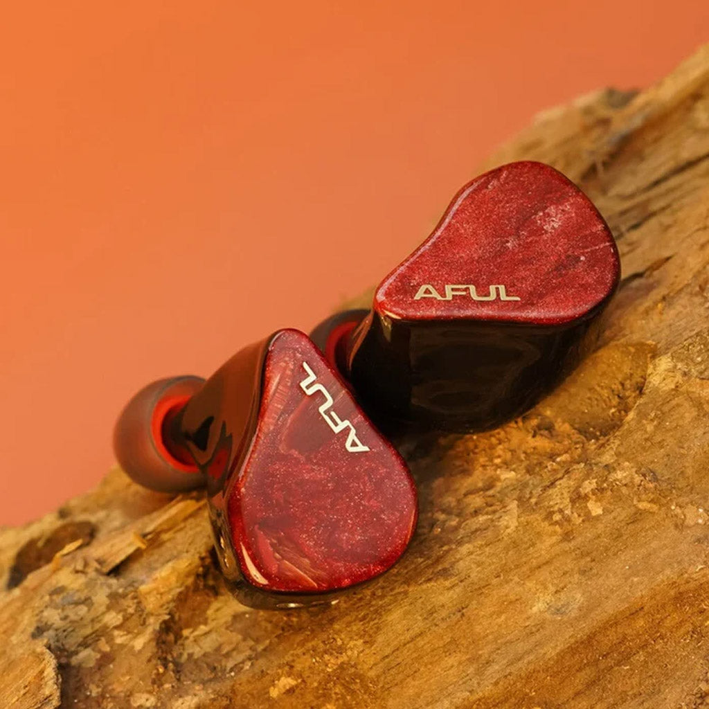 Close-up of AFUL DAWN-X in-ear monitors with shimmering red faceplates and ergonomic contours, ideal for immersive audio experiences.