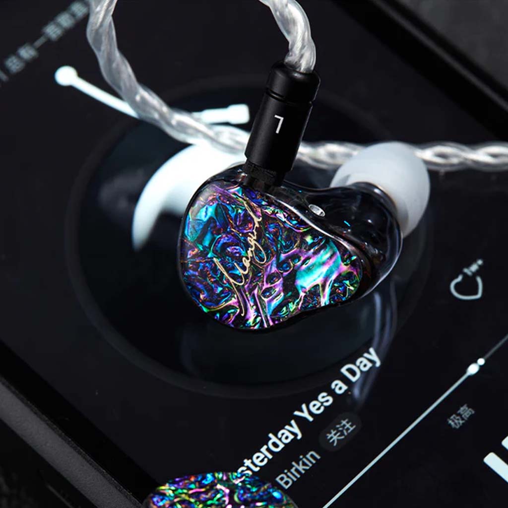 Mangird Top Pro IEM resting on a music player, showcasing its colorful faceplate and ergonomic design for immersive listening.