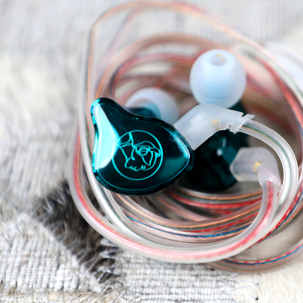Coiled AUDIOCULAR BR IEM with teal earpieces and transparent cable, highlighting compact and tangle-free storage.