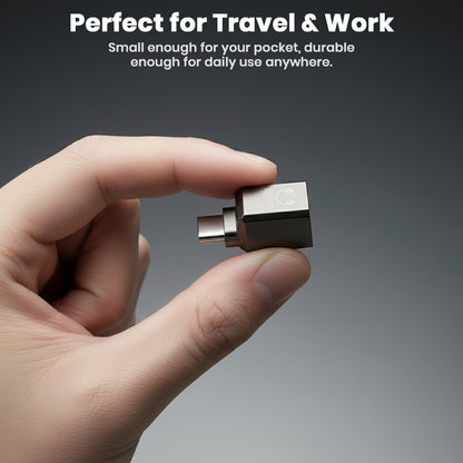 Compact AUDIOCULAR USB-C DAC Adapter held in hand, small and durable for travel and everyday use with USB-C audio devices.