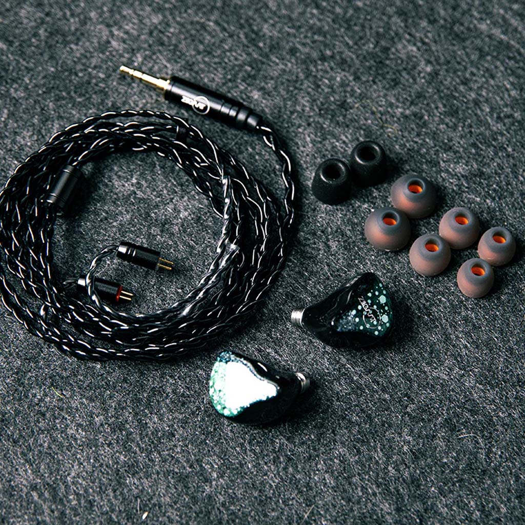 ZiiGaat Arcanis IEM unboxed with accessories including braided cable and multiple eartips, offering a complete high-end audio package.