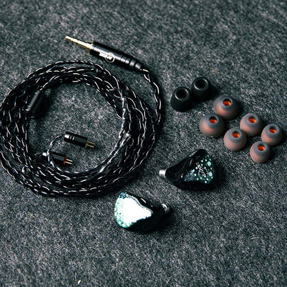 ZiiGaat Arcanis IEM unboxed with accessories including braided cable and multiple eartips, offering a complete high-end audio package.
