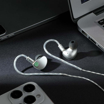 Soratune BI02 IEMs placed beside a laptop and smartphone, ideal for professional audio use and everyday listening on the go.