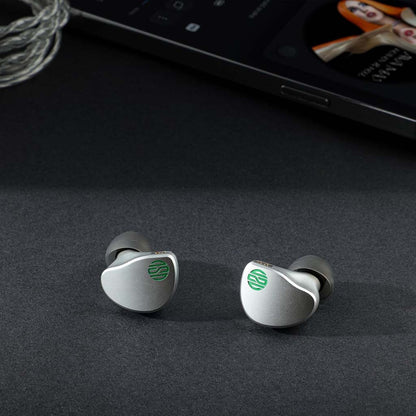 Pair of Soratune BI02 IEMs on a desk setup, showcasing premium build and compact design for high-quality portable audio.