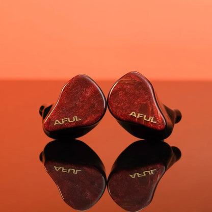 AFUL DAWN-X IEMs on reflective surface, highlighting premium red finish and gold AFUL logo for stylish, high-performance audio gear.