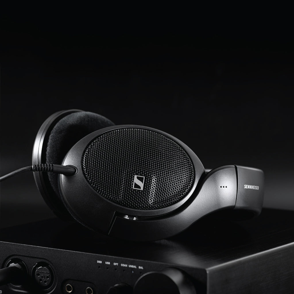 Sennheiser HD 560S headphones paired with an amplifier in a dark setting, highlighting their premium build and audiophile-grade performance.