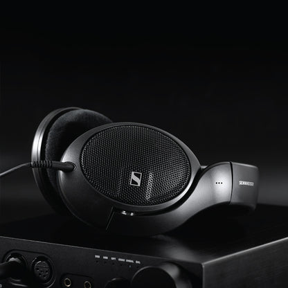 Sennheiser HD 560S headphones paired with an amplifier in a dark setting, highlighting their premium build and audiophile-grade performance.
