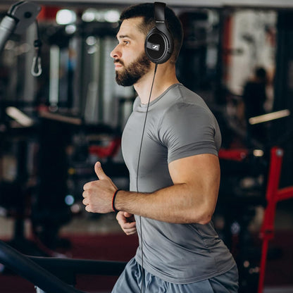 Man running on treadmill wearing Sennheiser HD 569 Closed-Back Over-Ear Headphones, showing secure fit and comfort during active use.
