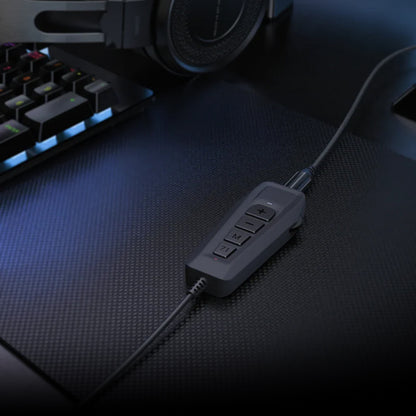 SIMGOT GEW1 USB Gaming Sound Card placed on gaming desk beside keyboard and headphones, ready for high-quality audio performance.
