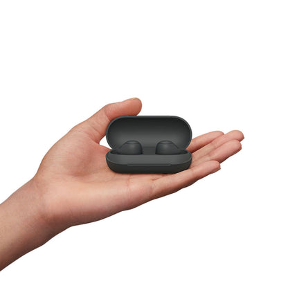 Sony WFC700N black earbuds in compact charging case held in hand, highlighting portability and sleek design for on-the-go audio.