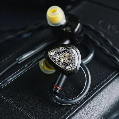 TANGZU Wan'er SG 2 black IEMs with braided cable placed on leather surface, highlighting elegant design and build quality.
