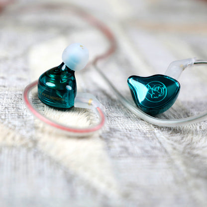 Pair of AUDIOCULAR BR 10mm Dynamic Driver IEMs on fabric surface, showcasing stylish teal design and ergonomic build.
