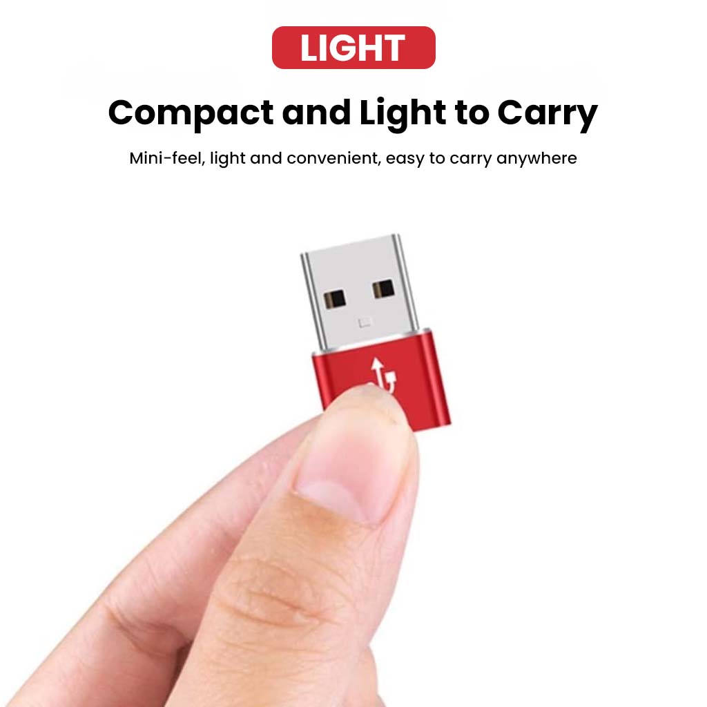 Compact and lightweight AUDIOCULAR OTG Adapter held between fingers, designed for portability and ease of use.