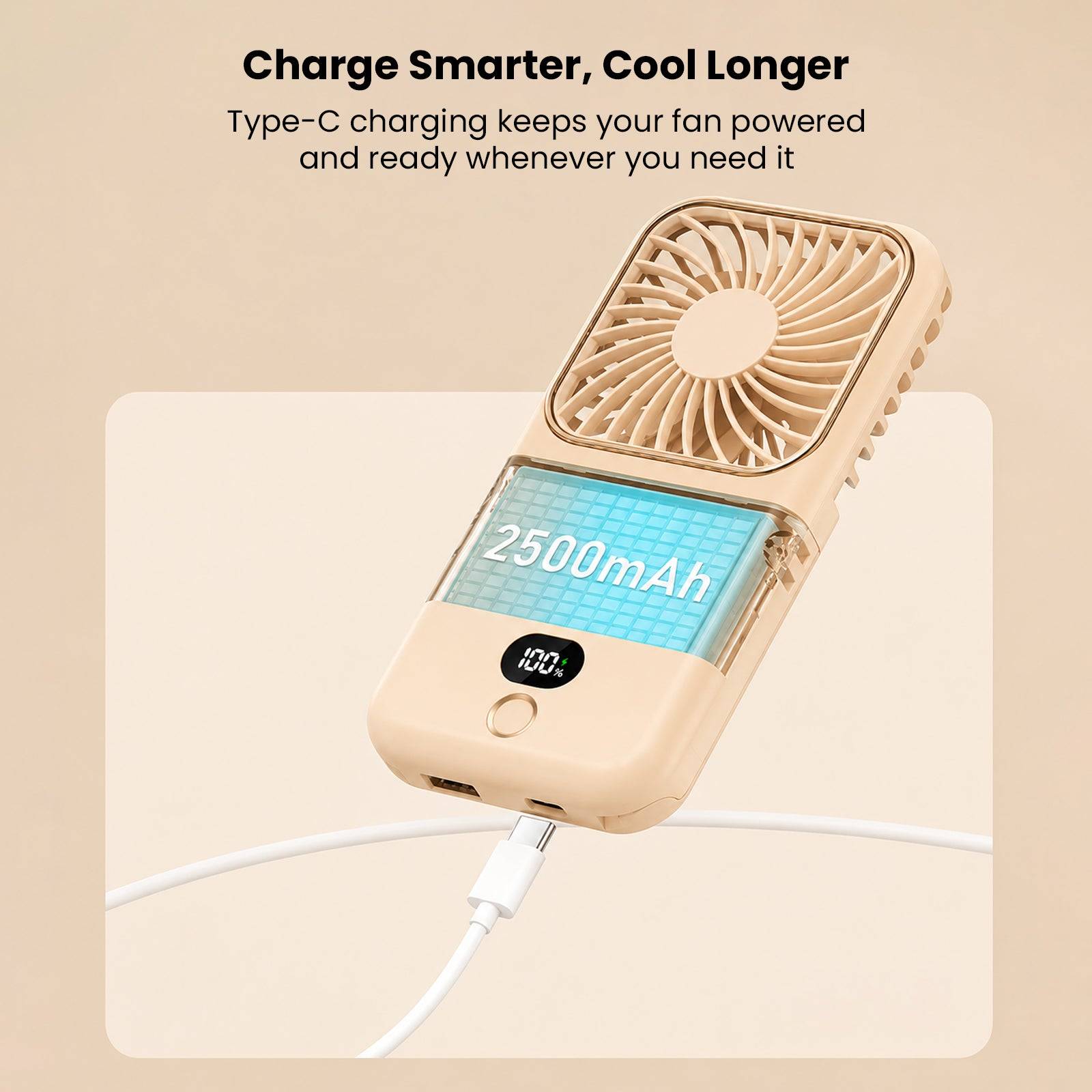 Mini portable folding handheld fan in beige with LCD display showing 2500mAh capacity, connected to a smartphone via USB charging cable