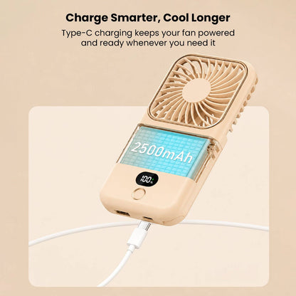 Mini portable folding handheld fan in beige with LCD display showing 2500mAh capacity, connected to a smartphone via USB charging cable