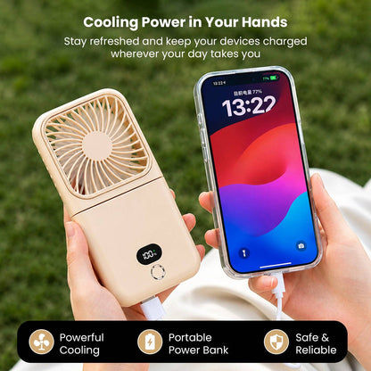 Person holding beige mini portable fan with LCD display and USB charging cable, demonstrating portable power bank feature outdoors