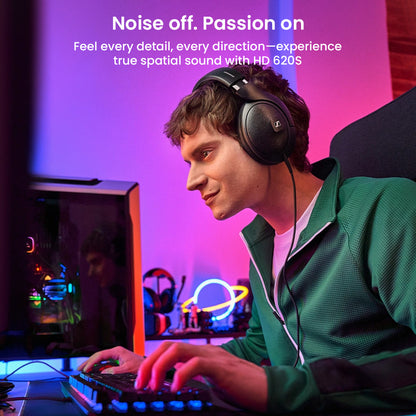 Gamer using Sennheiser HD 620S headphones at a desktop setup, emphasizing spatial sound and immersive detail for passionate audio experiences.