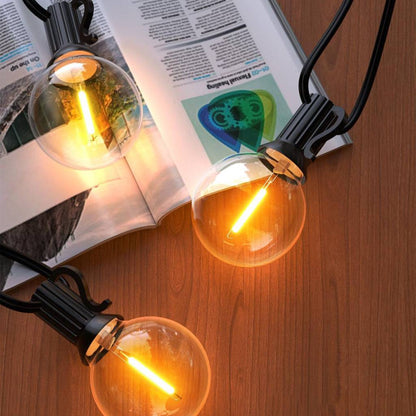 TECPHILE G40 outdoor string lights with waterproof and shatterproof bulbs, emitting a warm glow on a wooden surface. Ideal for patios and gardens.