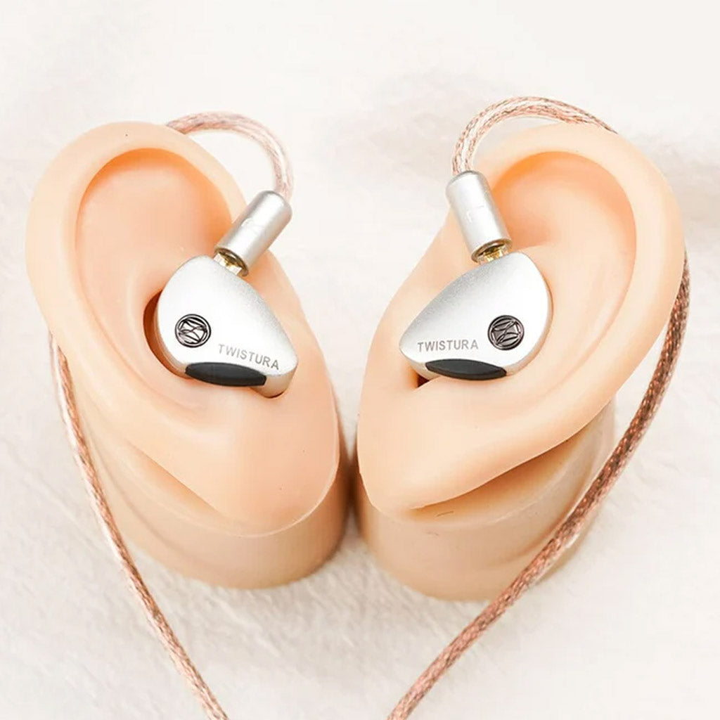 TWISTURA Woodnote IEMs shown in ear models, demonstrating ergonomic fit and secure over-ear cable design for extended listening.