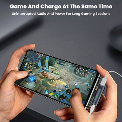 User gaming on a smartphone while using the AUDIOCULAR A14X adapter for simultaneous charging and audio.
